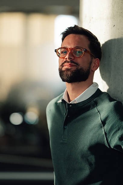 istock Confident man with beard and glasses standing by pillar 2252278248