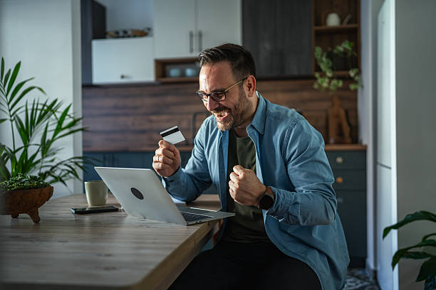istock Happy man shopping online using laptop and credit card 2252278455