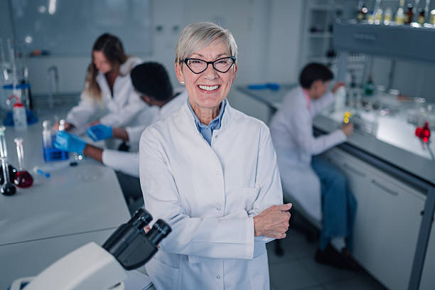 istock Senior female scientist smiling in laboratory with students 2252280107
