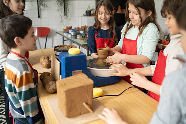 istock Children clustered around a potter's wheel 2252280380