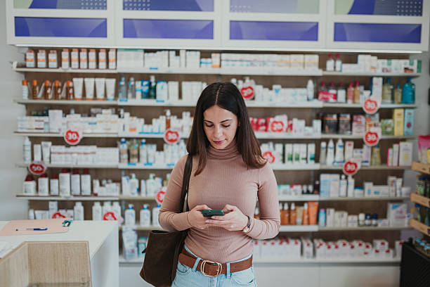 istock Woman using smartphone in pharmacy checking health products 2252284833