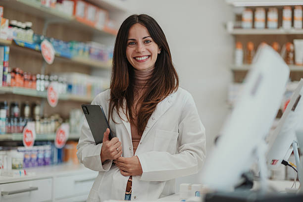 istock Female pharmacist smiling holding digital tablet in pharmacy 2252284928