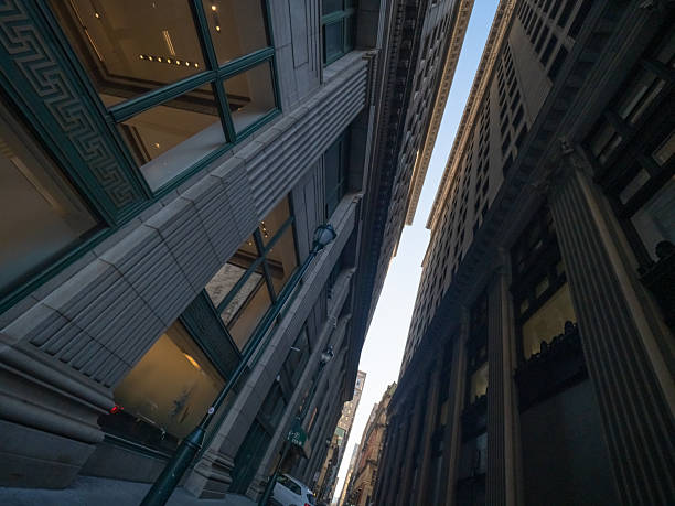 Tall buildings create a dramatic perspective in a narrow street showcasing architectural details in an urban environment.