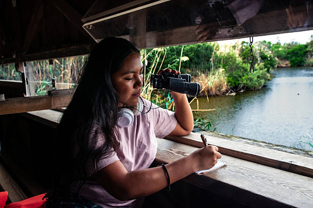 istock Young woman birdwatching and writing in tranquil hide 2252286781
