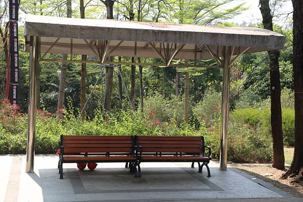 istock garden bench under a canopy structure, with a steel frame construction, set in a park setting with trees and flowers in the background 2252288279
