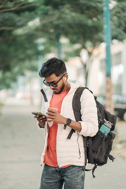 istock Young Man Using Smartphone While Walking on City Street 2252295153