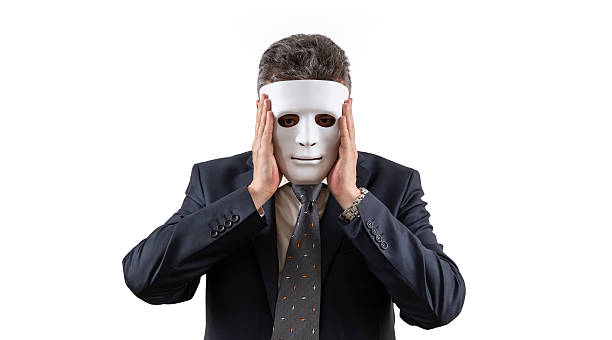 A middle-aged man in a business suit wearing a white mask
