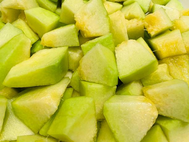 Fresh melon cubes neatly arranged in a bowl, showcasing their vibrant orange and green hues. A refreshing and visually appealing treat, perfect for any occasion.