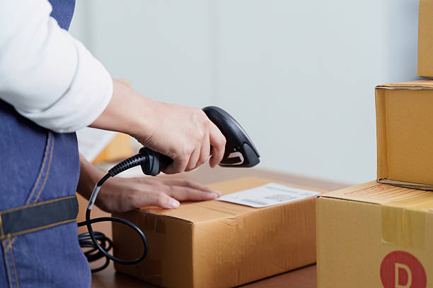 istock Inventory Management. Employee scanning package with barcode scanner in warehouse. 2252299912