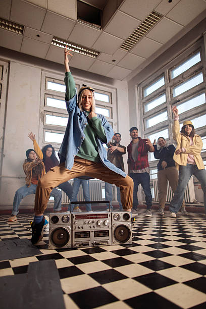 A lively group of friends dances in a retro-styled studio, centered on a bass-heavy boombox; The energetic pose and checkerboard floor convey music, movement, and urban friendship vibes