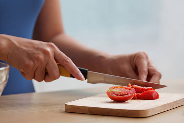 istock Wellness. Slicing ripe tomatoes for a nutritious salad. 2252300605