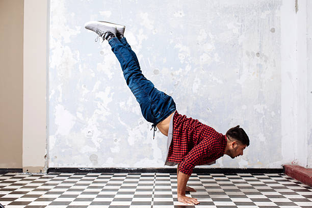 Young man upside down on one arm in front of seattle skyline at lake union against blue sky