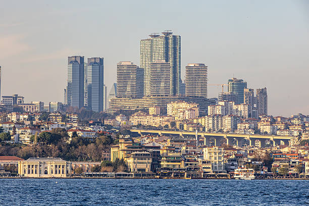 High-resolution panoramic photo of Istanbul showcasing modern residential and office towers contrasted with historic low-rise buildings along the Bosphorus shoreline. Urban bridge, waterfront and dense architecture highlight the city’s growth, lifestyle and investment appeal, ideal for travel, real estate and editorial use.