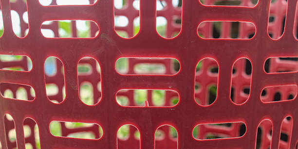 istock Close up detail of red plastic weave with symmetrical geometric hole pattern. 2252306085