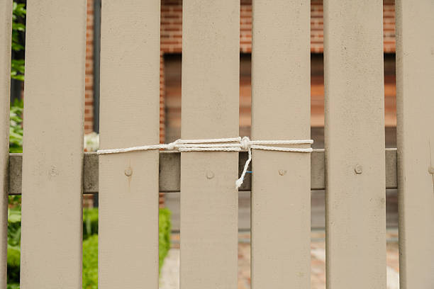 White string tied to a beige wooden fence.