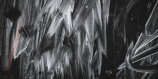 Abstract black grunge textured background with white scratches, stains, and dust effects. The rough, worn surface creates a dramatic, dark, and artistic impression.