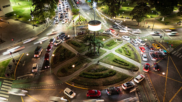 The most iconic city Christmas Tree, of the Rosario City, located on the cross of Pellegrini avenue and the Oroño boulevard. The photo show the Tree lit, also the traffic and the vibe of a Sunday night. On this photo it can be seen the traffic organized by the traffic lighs. Cars going on and cars stopped by the red light. Photo date: December 14, 2025. In the city of Rosario, Santa Fe province, Argentina.