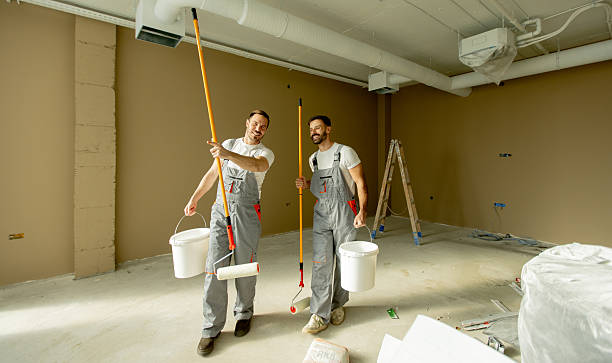 istock Two painters cheerfully working together in a newly painted office space 2252318792