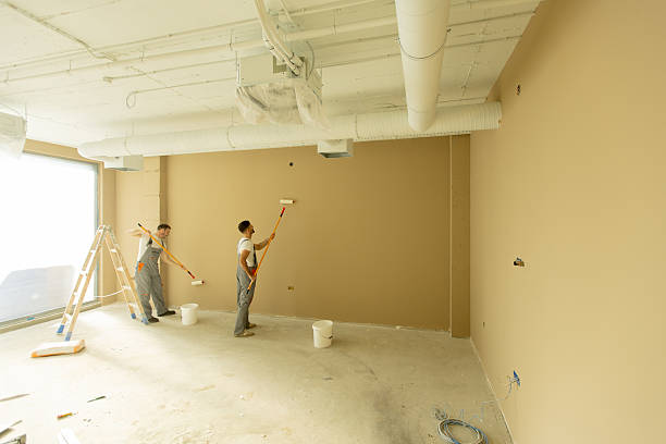 istock Workers painting a beige wall in a modern office space during daylight hours 2252318799