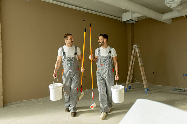 istock Two men carry painting tools and buckets while walking in a room during renovation work 2252318800