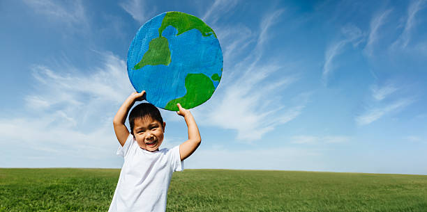 istock Child holds globe outdoors for environmental awareness 2252319393