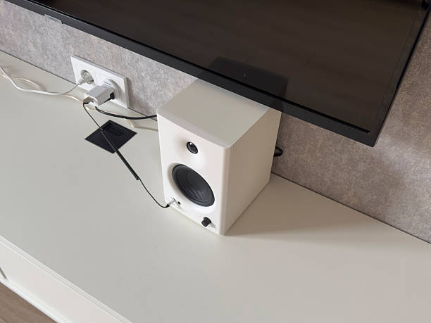 istock A speaker is connected to a television on a white surface in a simple room with soft lighting 2252322641