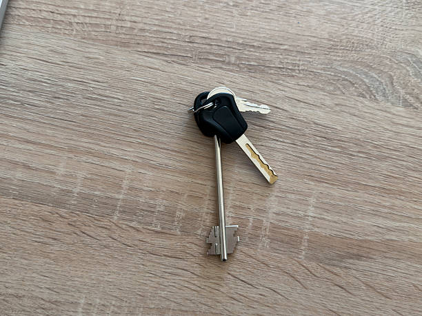 istock Keys and a car remote sit on a wooden table in a home environment during daylight 2252322678