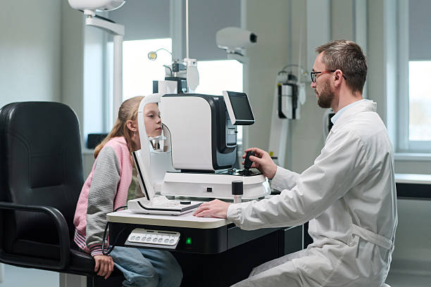 istock Male Optometrist Examining Young Girl Using Ophthalmic Device 2252322763