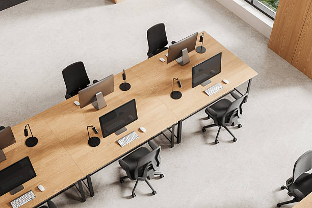 istock Modern open office interior design with wooden desks and computer workstations viewed from top perspective in bright environment. 3D Rendering 2252332663