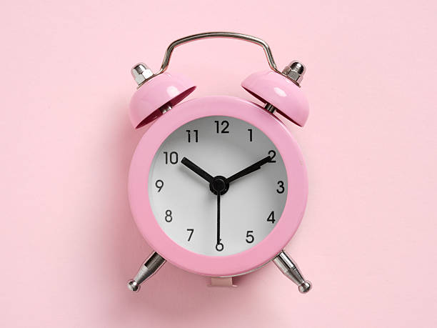 istock Pink alarm clock showing two o'clock on pink background 2252334452
