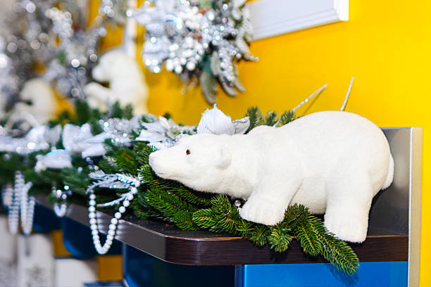 Plush white polar bear toy lounges on decorated shelf