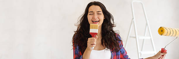 istock Woman Singing Into Paint Brush While Holding Roller During DIY Renovation 2252338539
