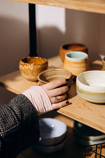 istock Woman examining handmade ceramic tableware in craft boutique. 2252338884