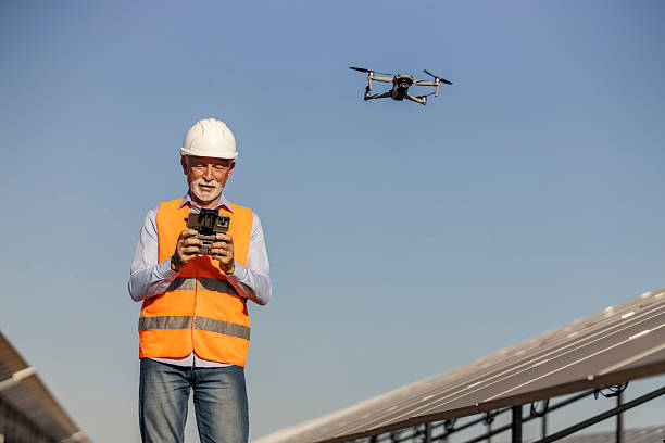 istock Senior male environmentalist operating drone at solar farm in bright daylight for renewable energy monitoring 2252339336
