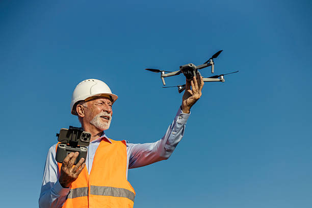 istock Senior male environmentalist wearing safety gear launching drone outdoors under clear blue sky 2252339487