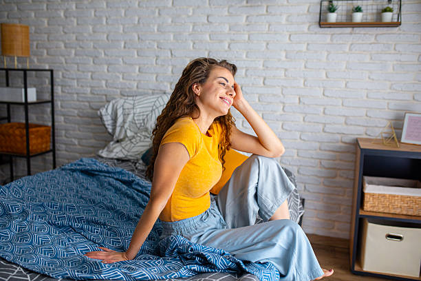istock Rested woman sitting on bed in the morning light 2252340508