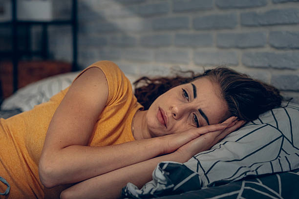 istock Exhausted woman resting in bed, unable to fall asleep 2252342146
