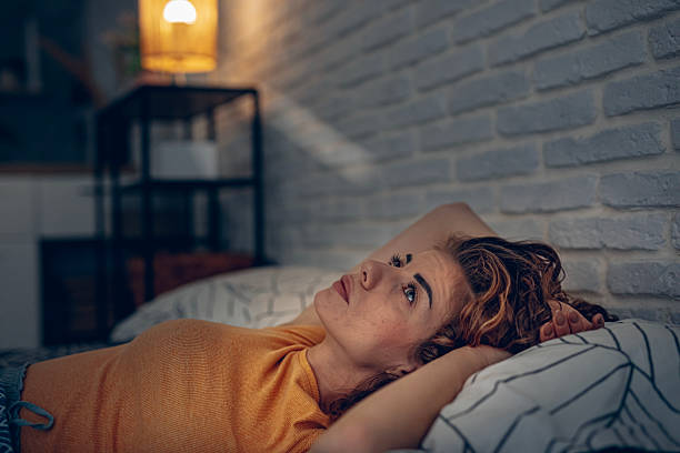istock Exhausted woman resting in bed, unable to fall asleep 2252342279