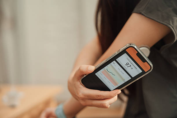istock Asian woman using CGM device on her arm to check her blood sugar level 2252346964
