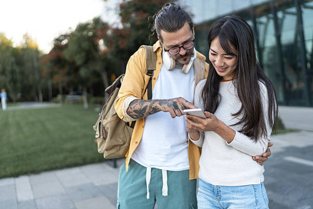 istock Multiracial couple using smartphone outdoors in park 2252349315
