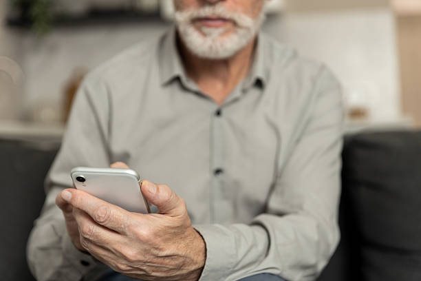 istock Man using smartphone at home for communication and online tasks in living room 2252352958
