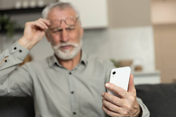 istock Older man uses smartphone in living room while looking confused about an app 2252352981