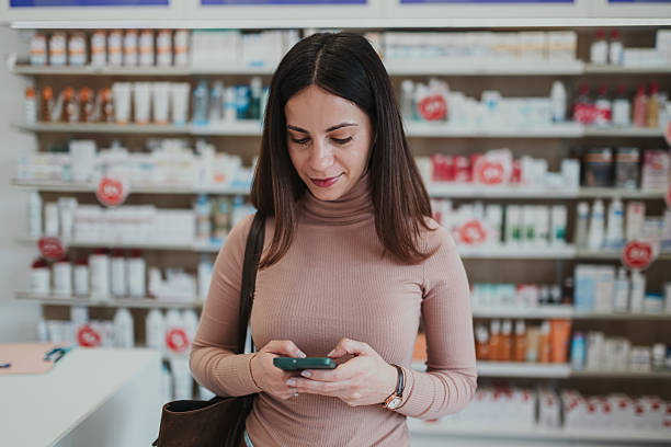 istock Woman using smartphone checking medicine information in pharmacy 2252355808
