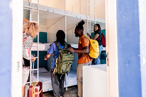 Young friends arriving on hostel room - Including non-binary person