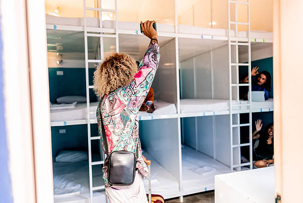 istock Young non-binary person arriving on hostel room 2252356425