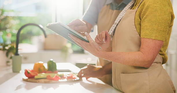 istock Couple, hands and vegetables with tablet for online cooking tutorial or healthy recipe in kitchen. Closeup, man or woman with technology or ingredients for research, natural organic food or meal prep 2252357270