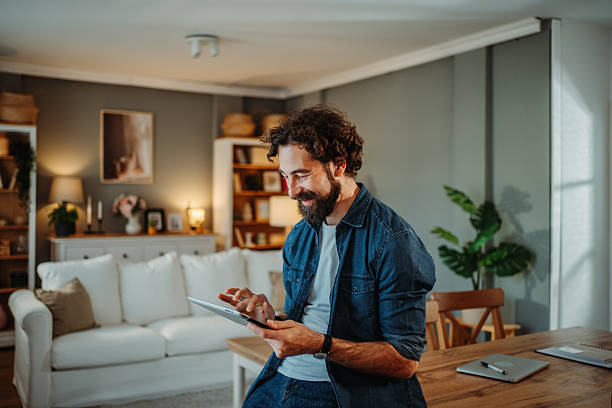 istock Man enjoying leisure time browsing digital tablet at home 2252357749