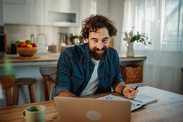 istock Man having online meeting from home kitchen 2252357835