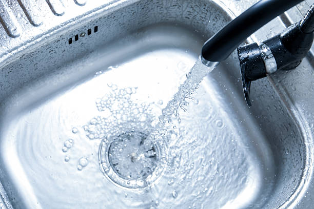 istock Water flowing from tap into sink, above view 2252359652