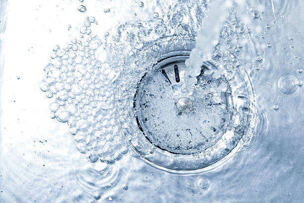 istock Stream of water going into sink drain, closeup 2252359657